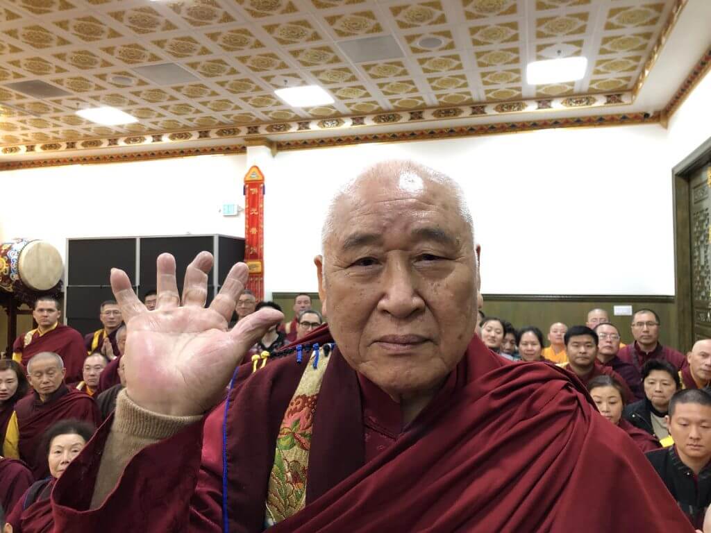 年近90歲的聖僧開初教尊用他三根手指頭已骨節折斷變形的右手，單手拿起了200磅金剛杵上基座，展顯了其上超十六段的聖力，遠超亞洲第一大力士，驚駭世人。 (攝影:楊慧君)